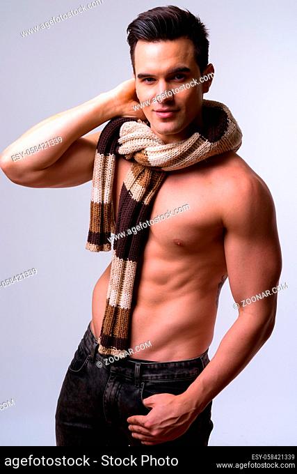 Studio shot of young handsome muscular man shirtless against white background