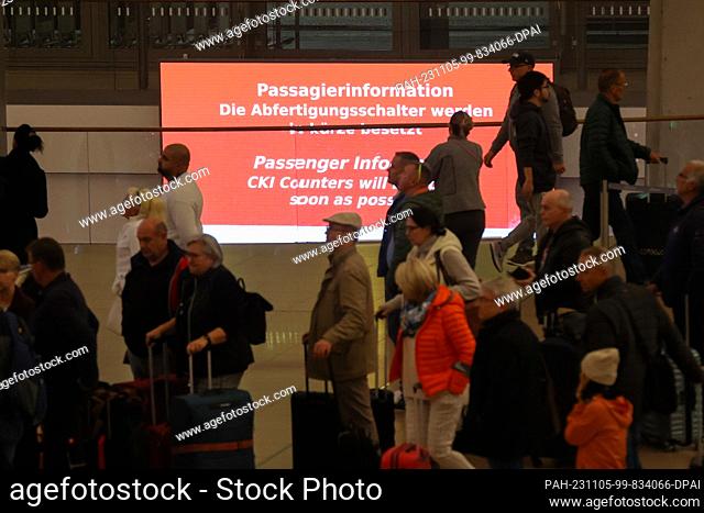 05 November 2023, Hamburg: Travelers are on the move in Terminal 1 at Hamburg Airport, a neon sign reads ""The check-in counters will be manned shortly""