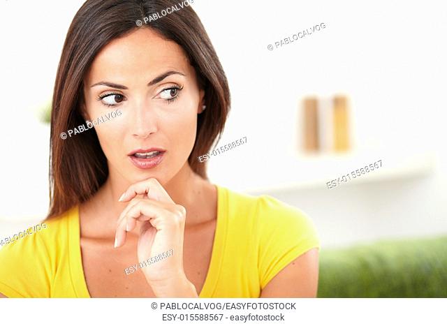 Surprised woman looking away while contemplating with one hand on her chin - copy space
