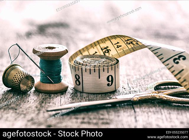 Creative image of tools and accessories for sewing on an old wooden surface. Concept. Selective focus. Retro style
