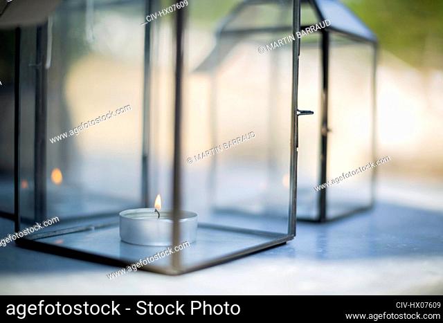 Close up tea light candle in clear glass lantern