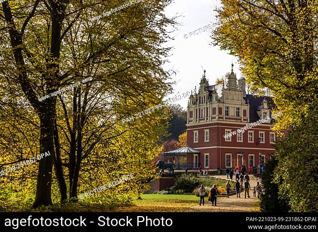 23 October 2022, Saxony, Bad Muskau: Walkers are out and about in sunny autumn weather at the New Castle in Prince Pückler Park in Bad Muskau