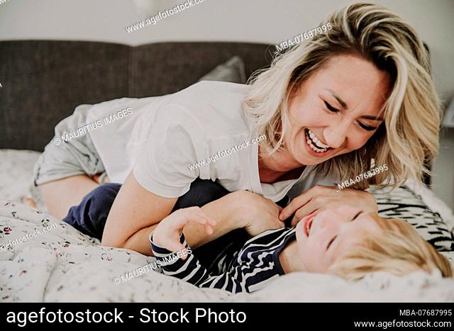 Mother and son in bed, having fun, fooling around