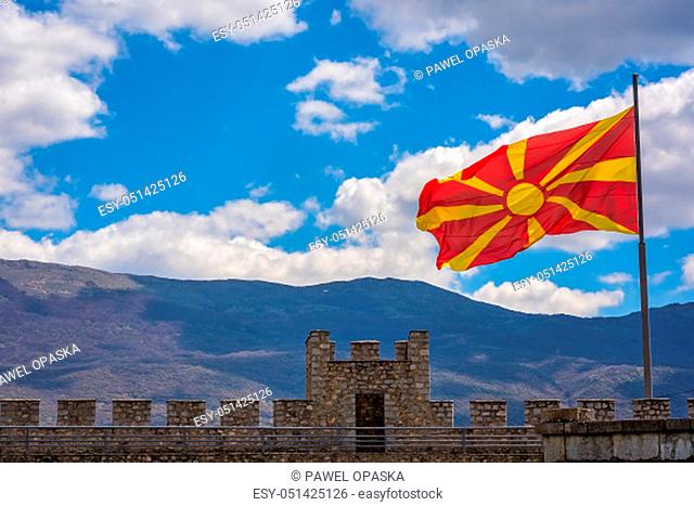Flag of Macedonia fluttering in a wind over walls of the castle Samuil, located above Ohrid lake, Republic Of Macedonia