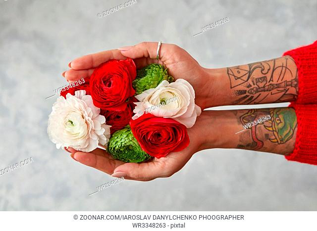 beautiful bouquet made of different flowers in young girl hands on a grey background . Mix colorful flowers