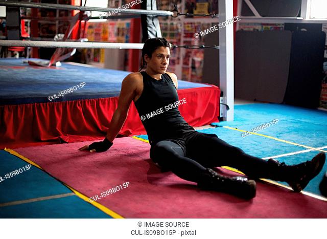 Female boxer resting in gym