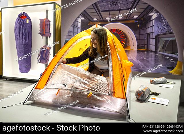 28 November 2023, Bavaria, Munich: An exhibitor presents a one-man tent at the Ferrino stand during the ISPO sporting goods trade fair at Messe München