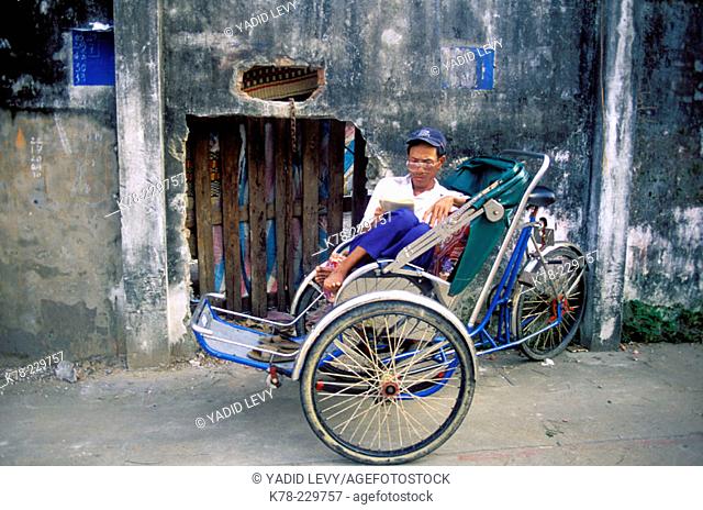 Rickshaw driver having a rest. Vietnam