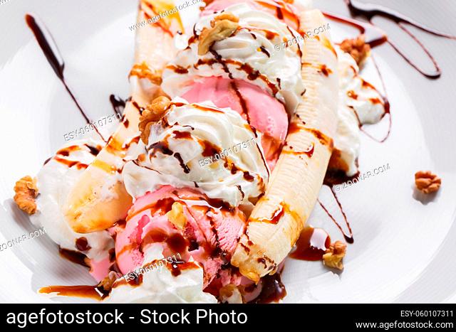 Banana split ice cream with whipped cream, nuts and cherry