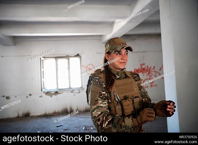 military army female soldier lady killer having a break in urban  modern warfare enviroment preparing gear for action