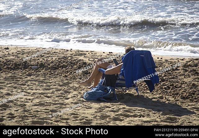 11 December 2023, Spain, Palma: A man sunbathes on the Arenal beach on a sunny day with a record temperature of 24 degrees. Photo: Clara Margais/dpa