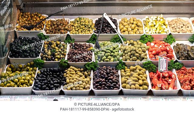 17 November 2018, Hessen, Frankfurt/Main: Olives and stuffed tomatoes are for sale at a stand in Frankfurt's Kleinmarkthalle