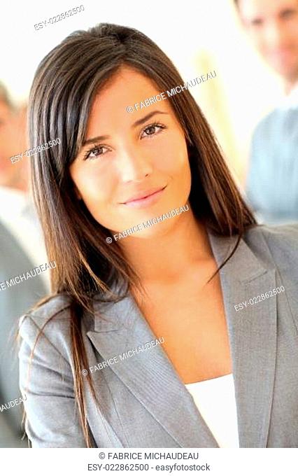 Portrait of beautiful businesswoman standing in front of group