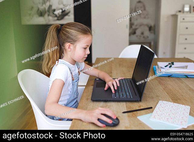 girl working on her laptop during home schooling during corona crisis