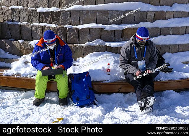Czech journalists Martin Hasek, left, and Michal Osoba work on laptops while waiting at bus stop in the Yanqing district of Beijing, China, February 15, 2022