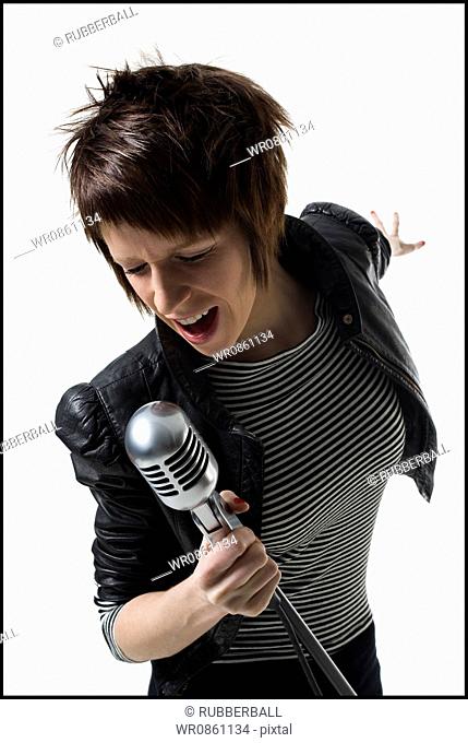 A young woman singing into a microphone