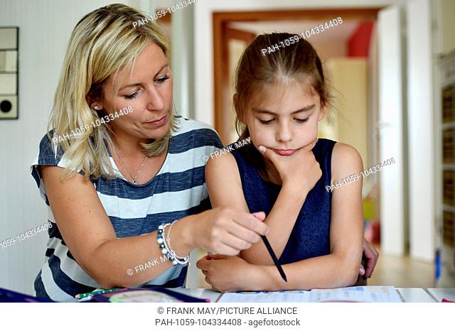 Girl is doing her homework with the help of her mother, , Germany, city of Osterode, 23. May 2018. Photo: Frank May (model released) | usage worldwide