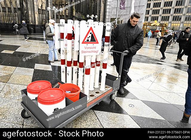 21 December 2023, North Rhine-Westphalia, Cologne: Employees of the City of Cologne put up signs warning of falling rocks. Photo: Roberto Pfeil/dpa