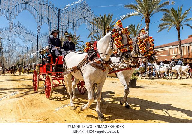 Spaniards in traditional festive dress on decorated horse-drawn carriage, Feria de Caballo, Jerez de la Frontera, Cádiz province, Andalusia, Spain
