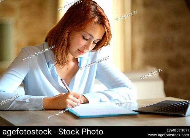 Concentrated entrepreneur signing contract sitting at home