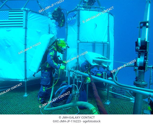 NEEMO 14 crew member Andrew Abercromby (right) enters the ascent module mock-up while Tom Marshburn looks on during an undersea session of extravehicular...