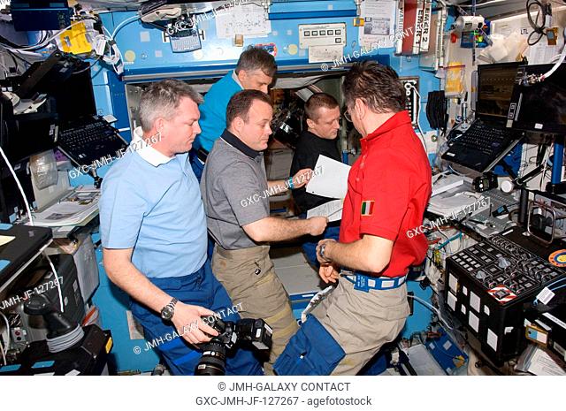 Expedition 27 crew members discuss mission activities in the Destiny laboratory of the International Space Station. Pictured clockwise from the left are Russian...