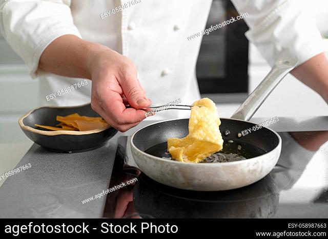 Close-up view of male chef cooking on frying pan. High quality photo