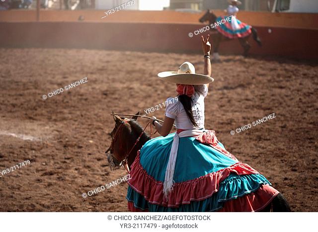 "An escaramuza make a sign to her team while competing in an Escaramuza in the Lienzo Charros el Penon, Mexico City, Sunday, January 19, 2013