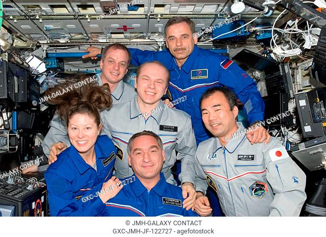 Expedition 23 crew members pose for a in-flight crew portrait in the Destiny laboratory of the International Space Station while space shuttle Discovery...