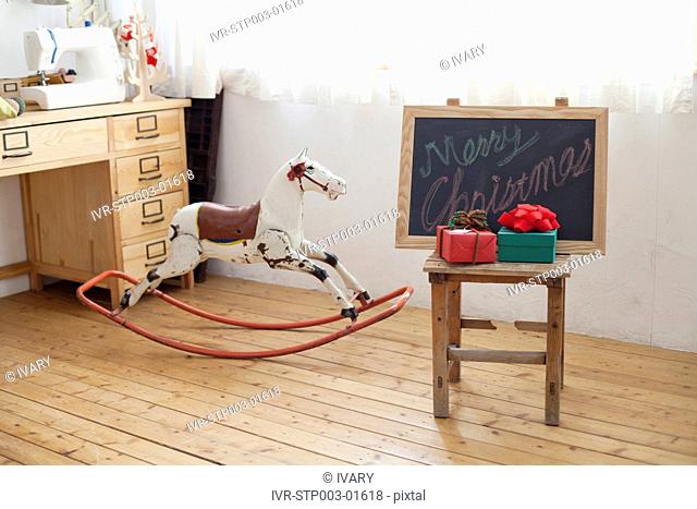 Child Room Interior With Christmas Presents Rocking Horse And Black Board