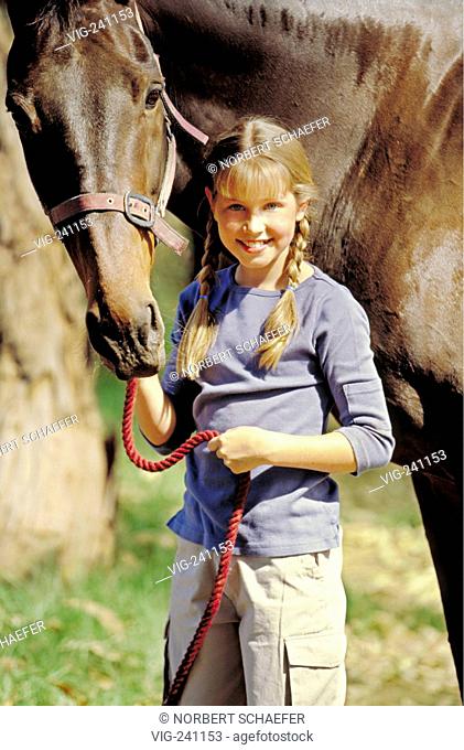 portrait, girl, 12 years, with long blond plaits with her haltered horse  - GERMANY, 25/01/2004