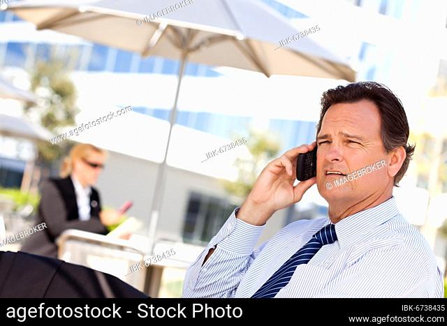 Confident, handsome businessman smiles as he talks on his cell phone