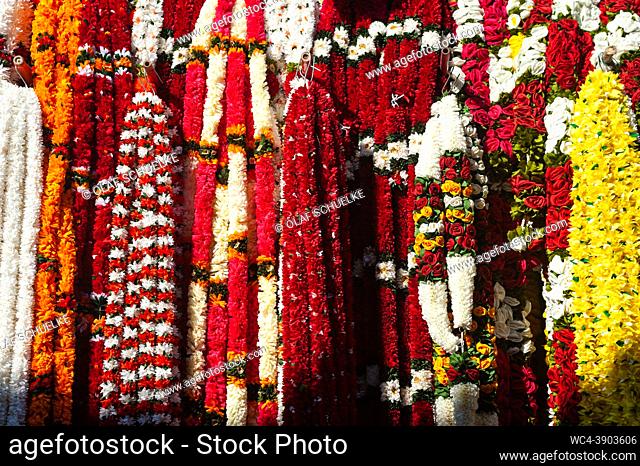 Singapore, Republic of Singapore, Asia - Decorative ornaments and colourful flower garlands made of plastic are displayed for sale at a street market in Little...