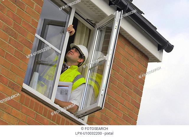 Construction manager inspecting windows in a new build house