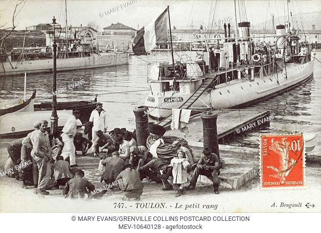 Toulon, France - Sailors playing cards sat on a small quay. The crew are from the Rochefortais class (or Pertuisane class) destroyer 'Rapiere' of the French...