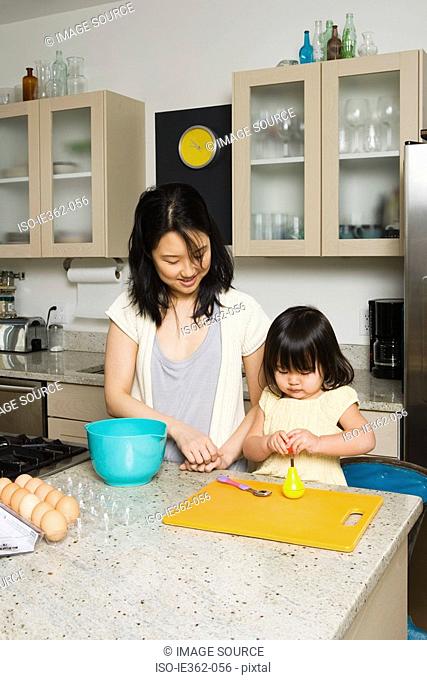 A daughter helping her mother in the kitchen
