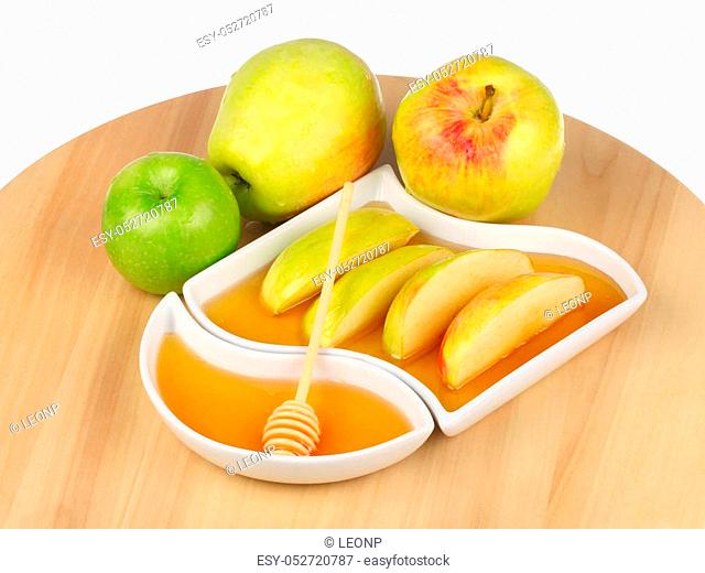 apples and dipping slices of apple in honey for Rosh HaShanah, the Jewish New Year