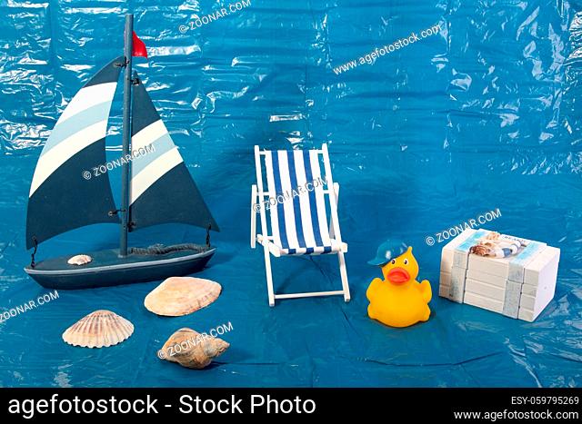 Summer Vacation Concept with toy boat with deck chair an Treasure chest on blue background