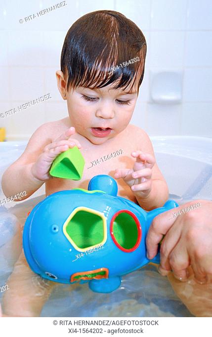 Baby at the tub playing with toy