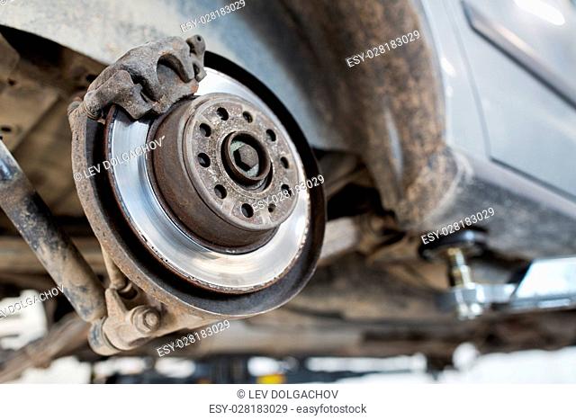 auto service and maintenance concept - car brake disc at repair station