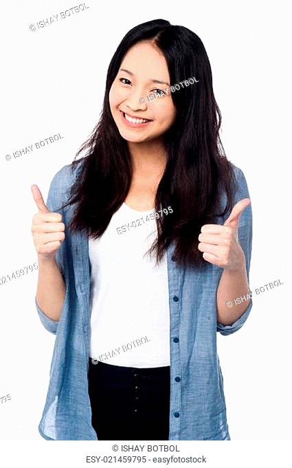 Smiling young girl showing two thumbs up