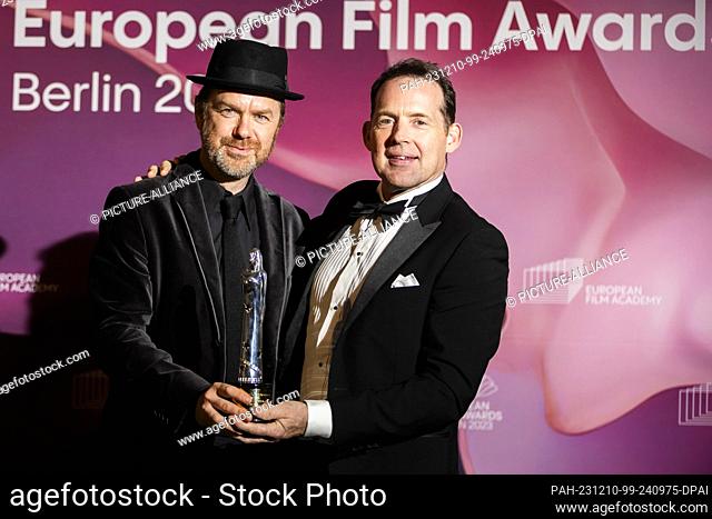 09 de diciembre de 2023, Berlín: Johnnie Burn (r) y Tarn Willers, ganador de "El sonido europeo", presentan su premio a la película "La zona de interés" en la...