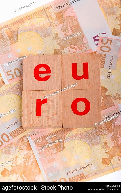Letter on blocks on top of some 50 euro banknotes