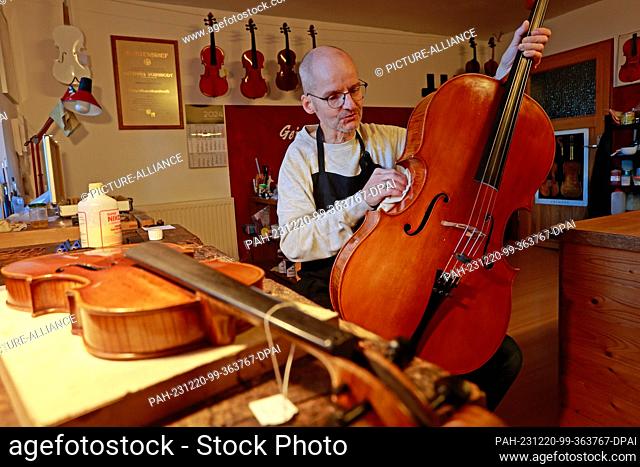 20 December 2023, Saxony-Anhalt, Wernigerode: Master violin maker Matthias Vorbrodt polishes a viola in his workshop. The instrument is one of many that can...