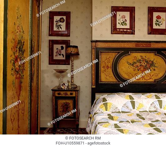 Antique inlaid floral-pattern bed with matching wardrobe and cabinet below floral pictures
