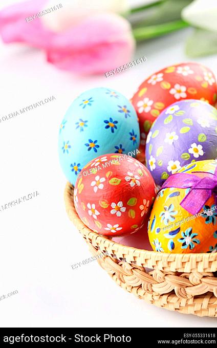Easter decorations - flowers, basket with painted eggs on white
