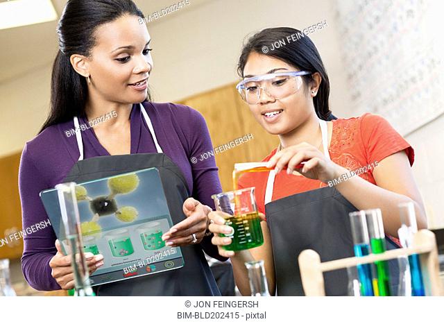 Teacher and student working with chemicals in classroom