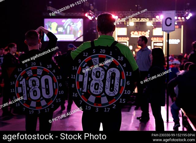 30 March 2023, Berlin: Darts: Premiere League, 9th matchday in the Mercedes-Benz Arena. Fans in dartboard costumes enter the interior of the Mercedes Benz Arena...