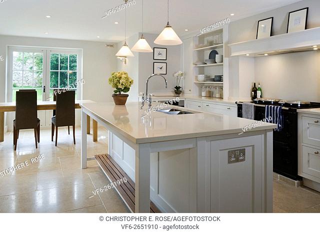 Large island unit in a bright light kitchen with dining area beyond. Editorial Use Only