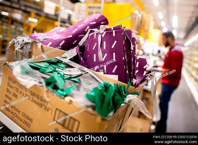 07 December 2023, Lower Saxony, Großenkneten: An outgoing goods employee prepares ordered gift items for shipping at Amazon's new logistics center at the former...